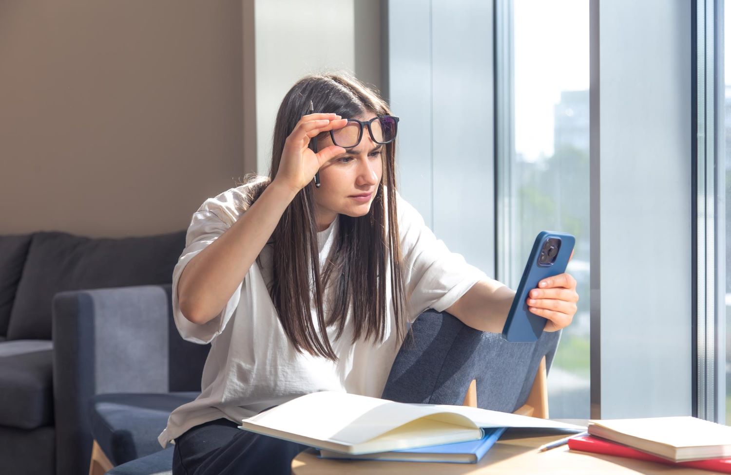 Jovem usando celular e notebook com sintomas de fadiga ocular