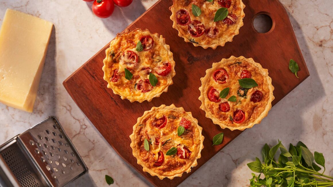 Mini quiche caprese com tomate cereja e manjericão servida em prato