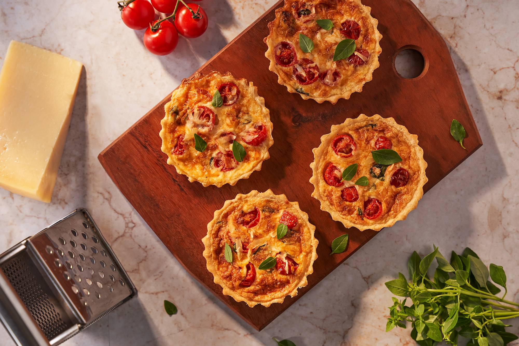 Mini quiche caprese com tomate cereja e manjericão servida em prato