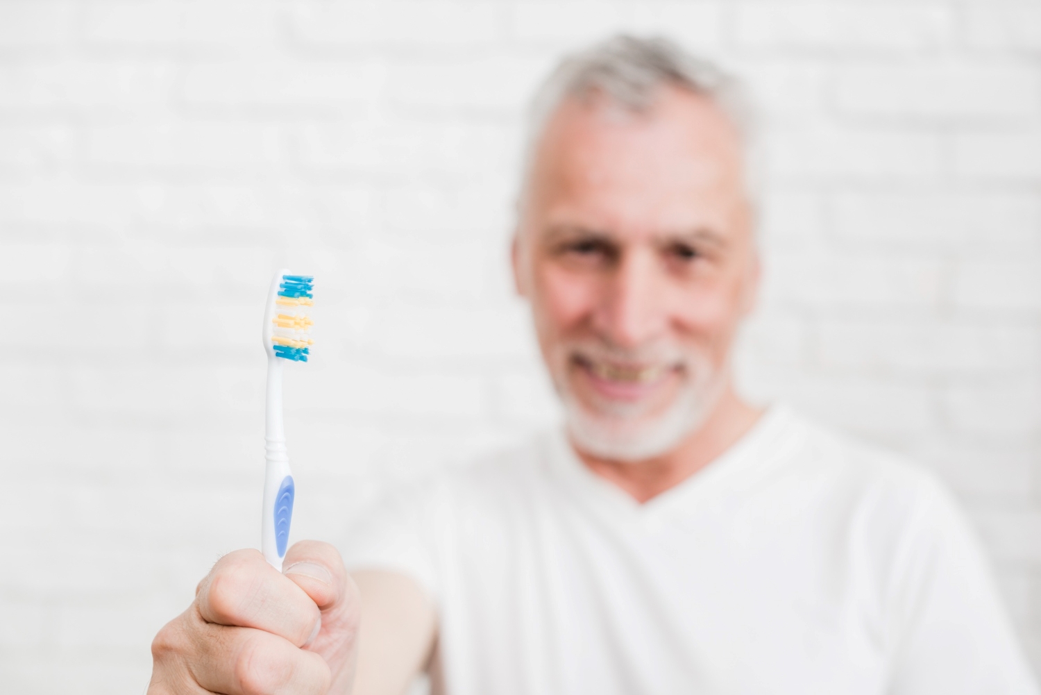 Dentista avalia a saúde da gengiva de uma paciente idosa durante consulta odontológica.