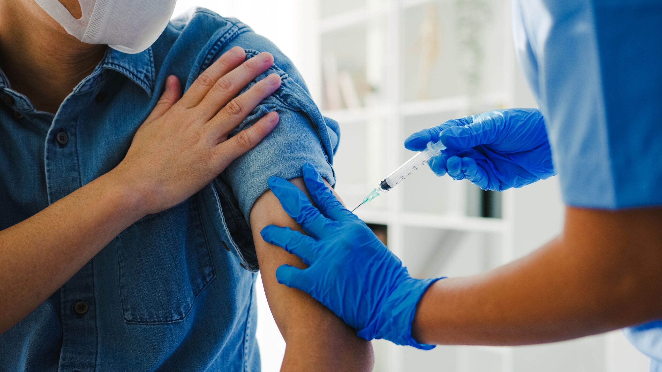 Profissional de saúde prepara vacina para reforçar a importância da imunização em adultos.